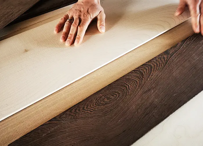 Edle Hölzer & Materialien für Möbel nach Maß Verschiedene Holzarten und -muster liegen nebeneinander und zeigen die natürliche Vielfalt von Farben, Maserungen und Strukturen. Die ausgewählten Hölzer dienen als Grundlage für die Gestaltung von maßgefertigten Tafelparkett und Möbeln.